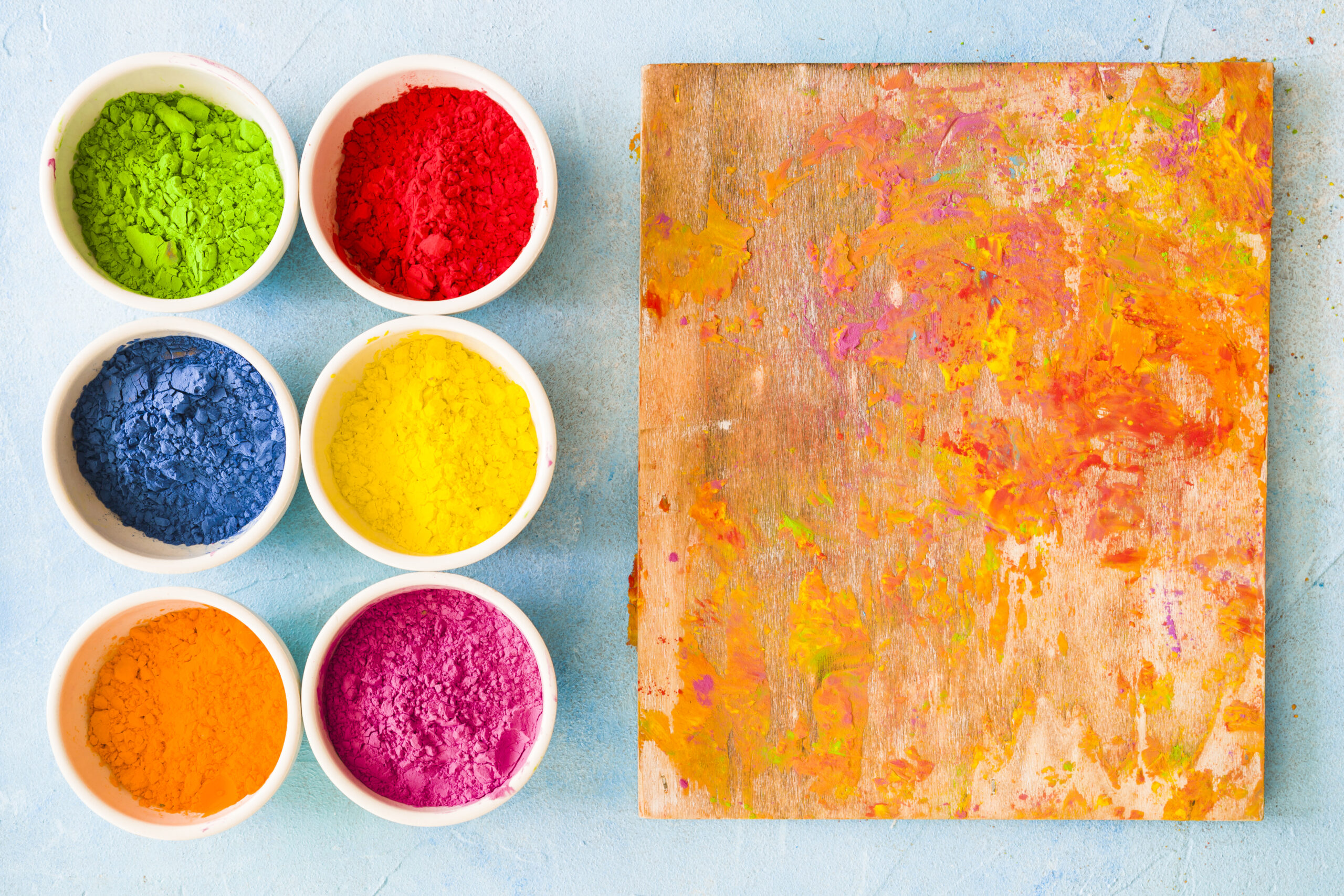 wooden-board-mess-with-holi-color-powder-painted-background